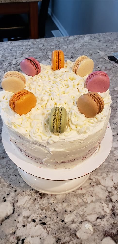Cream cake with colorful macarons